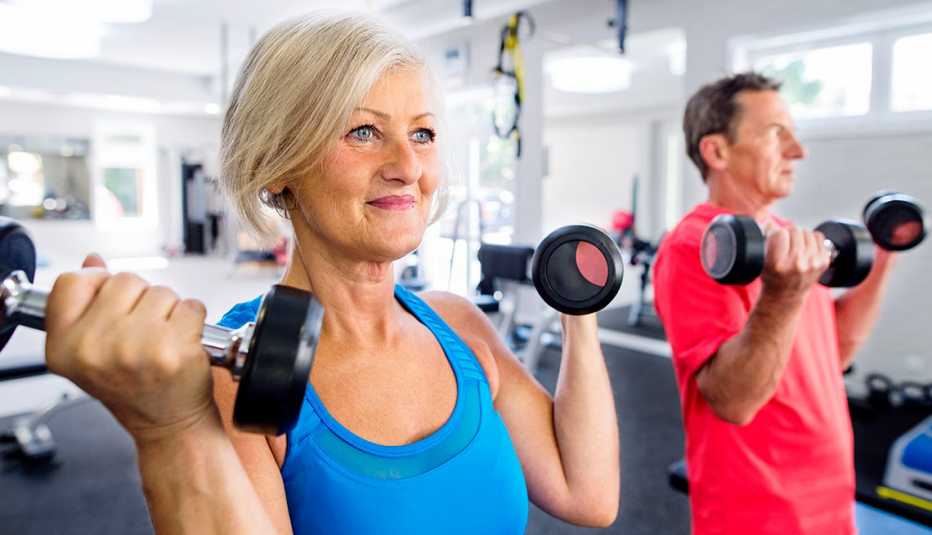 Una mujer y un hombre se ejercitan en un gimnasio Una mujer y un hombre se ejercitan en un gimnasio