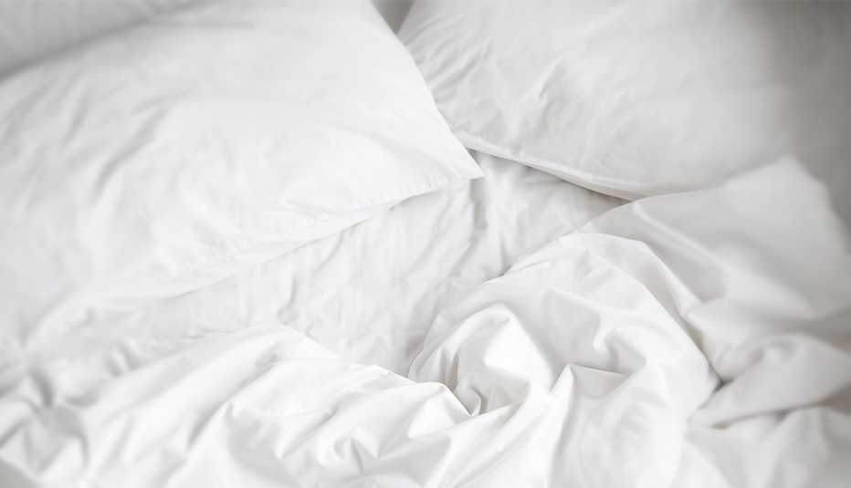 Sábanas blancas con almohadas.