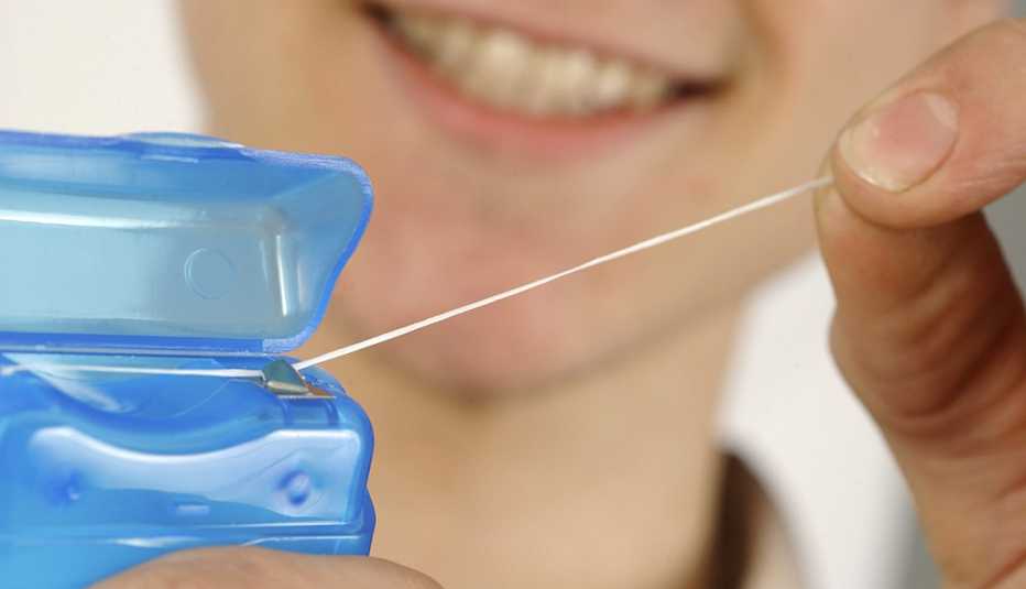 Una persona toma un pedazo de hilo dental