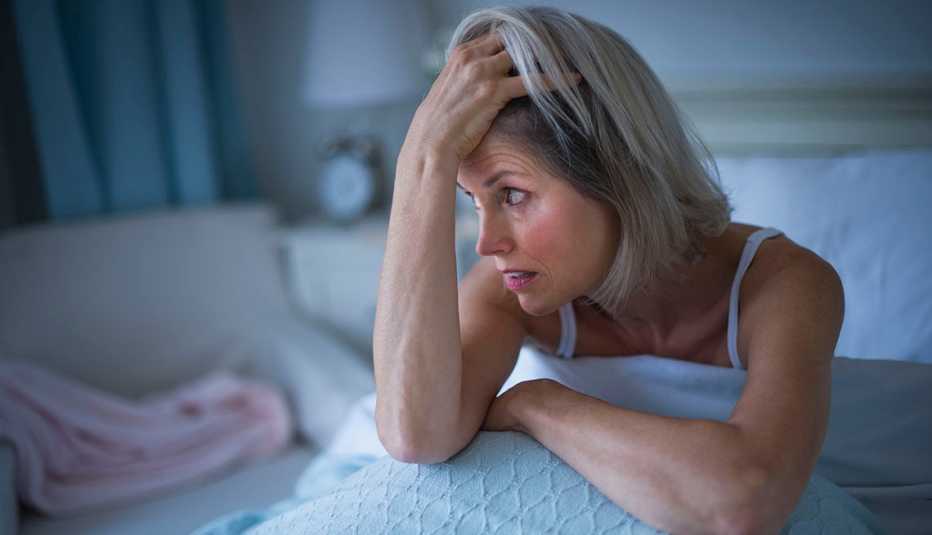 Una mujer en su cama sin poder dormir