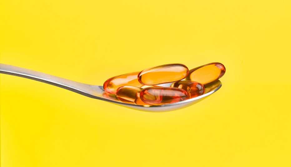 Una cuchara con varias cápsulas de aceite de pescado
