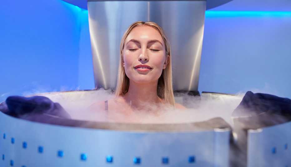 Una mujer, con sus ojos cerrados, en una cabina de crioterapia de cuerpo entero