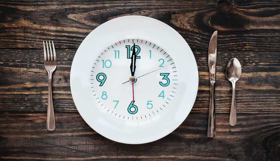 Un plato sobre una mesa con un reloj en la cara del plato