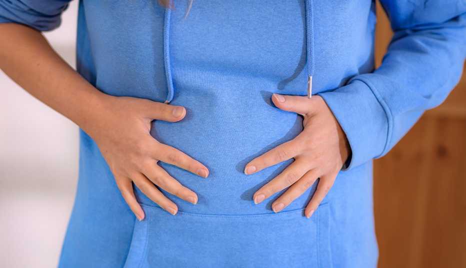 Una mujer se lleva las manos al vientre