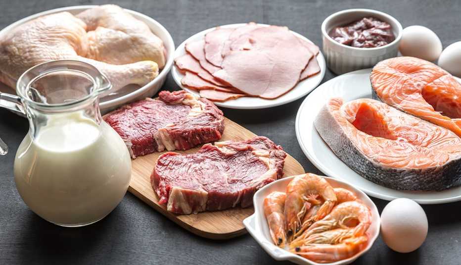 Platos de carne, pescado, pollo y huevos y una jarra de leche