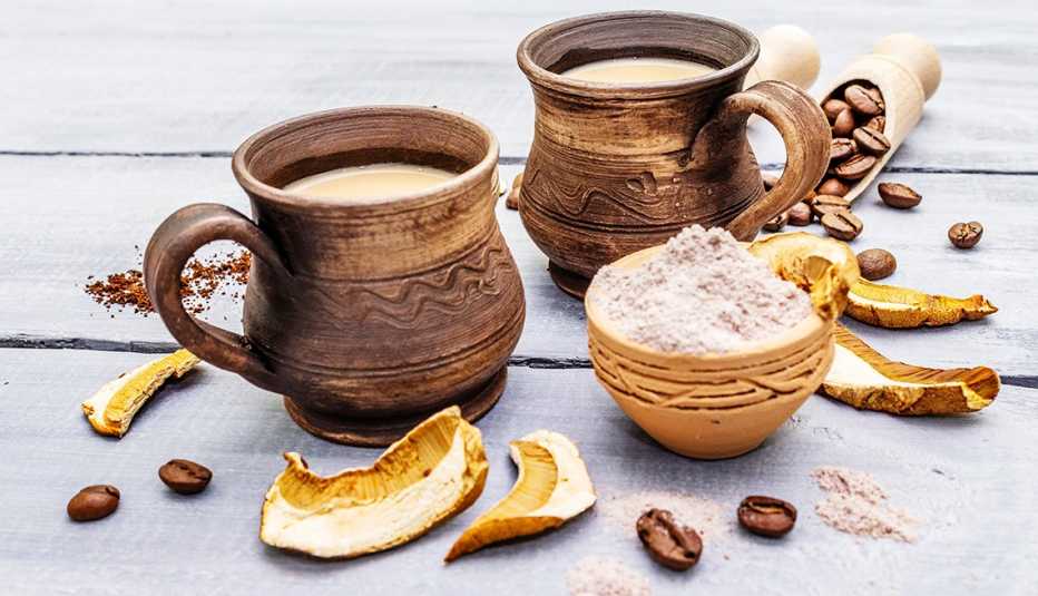 mugs of mushroom coffee with coffee beans and dried mushrooms