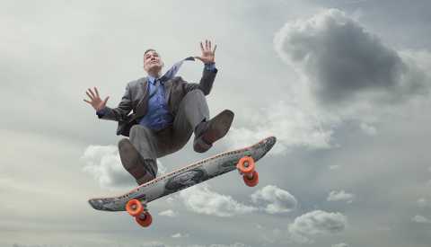 Ejecutivo en una patineta con el cielo de fondo. Ejecutivo en una patineta con el cielo de fondo.