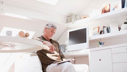 Hombre leyendo unos libros desde su casa Hombre leyendo unos libros desde su casa