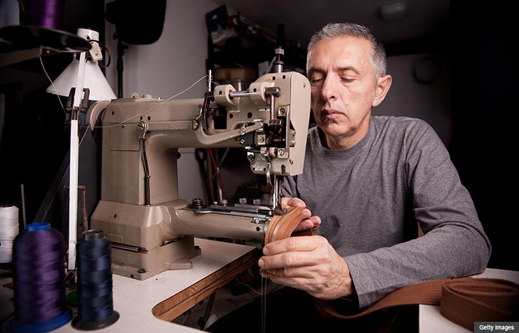 Hombre con una máquina de cocer, talentos naturales que hacen dinero Hombre con una máquina de cocer, talentos naturales que hacen dinero