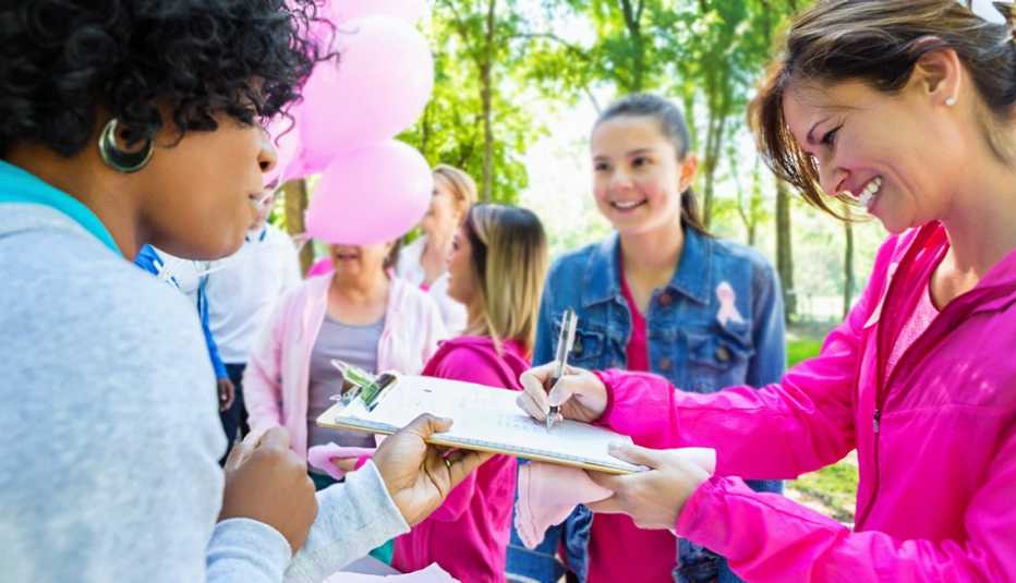 Mujeres en un parque mientras una firma una factura