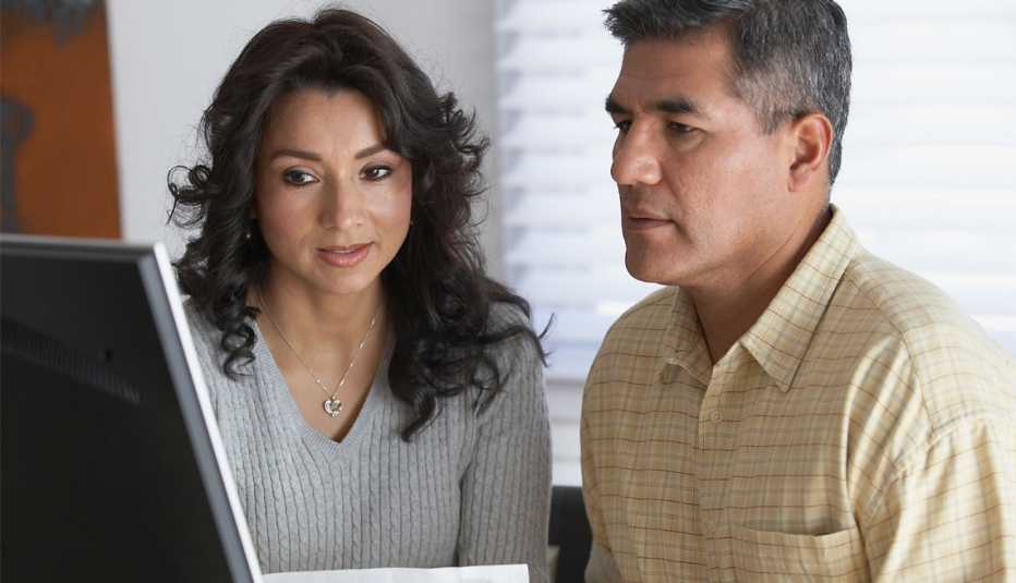 Una pareja hispana frente a un laptop