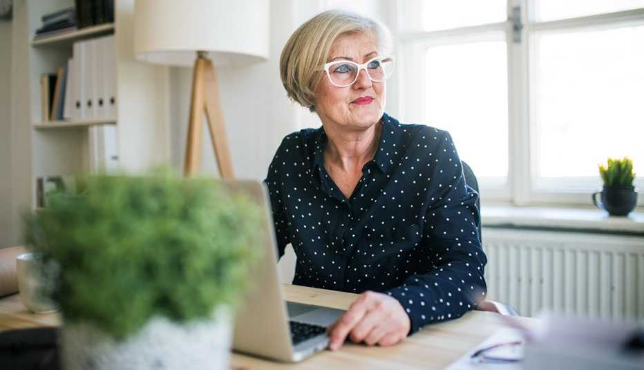 Mujer trabajando desde su casa en su computadora personal 