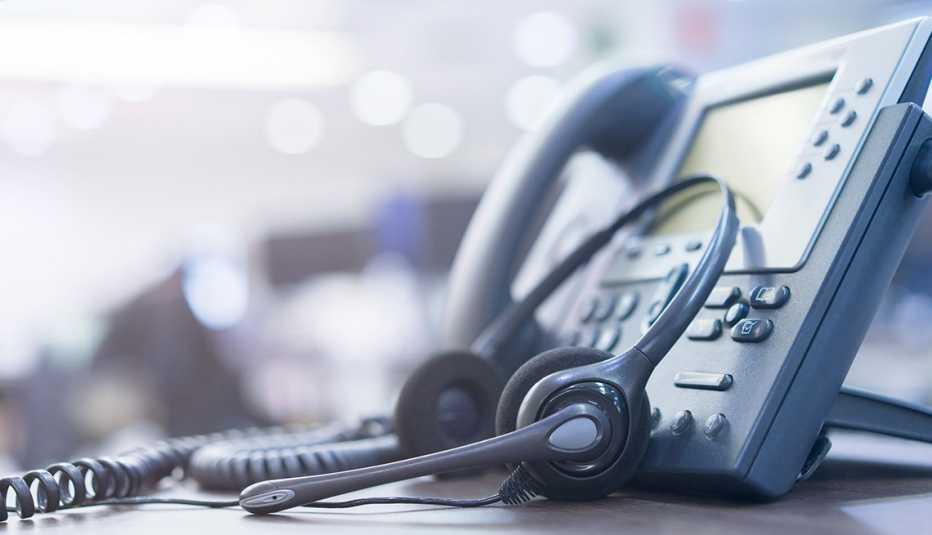 Teléfono de una oficina con un auricular y audífono al lado
