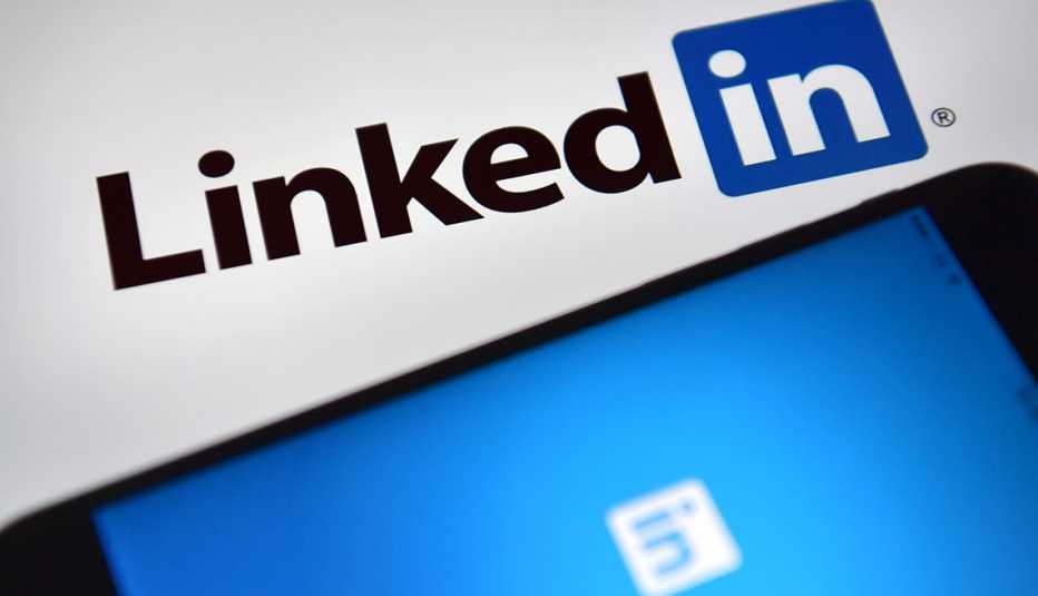 Logo de LinkedIn al lado de un móvil que muestra la aplicación de la compañía