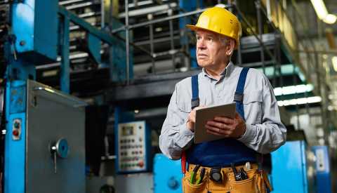 Hombre mayor trabajando en una fábrica.