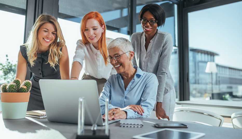 Mujeres viendo una computadora en una oficina