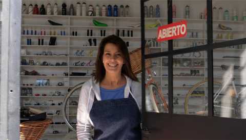 woman in an apron standing in the doorway of her bicycle shop woman in an apron standing in the doorway of her bicycle shop
