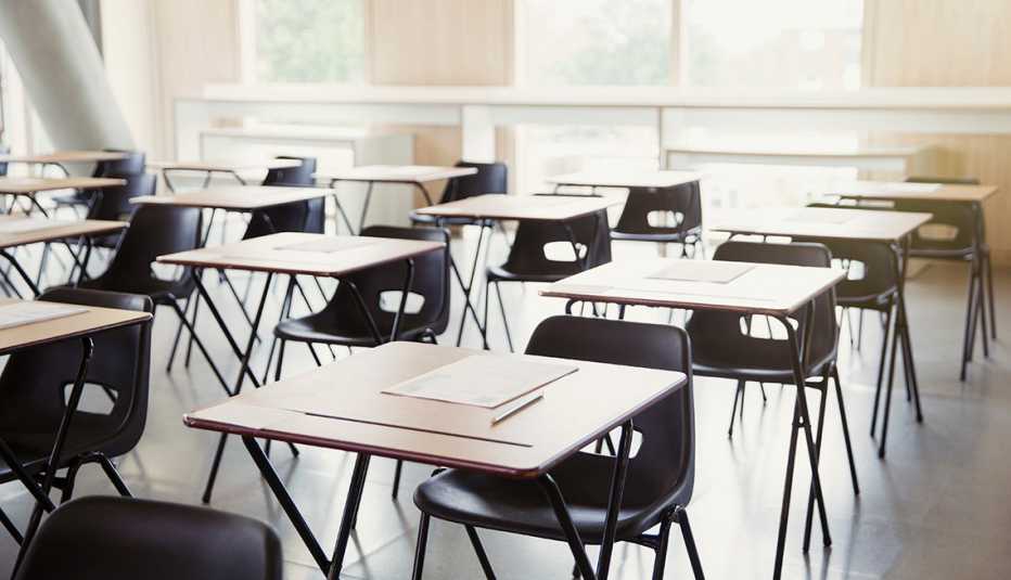Salón de clases con escritorios y sillas vacías
