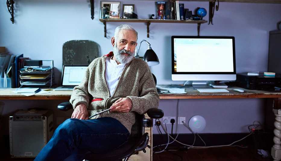 Hombre mayor sentado en un escritorio Hombre mayor sentado en un escritorio