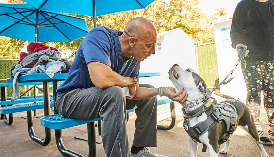 Kwane Stewart, veterinario voluntario acaricia a un perro Kwane Stewart, veterinario voluntario acaricia a un perro