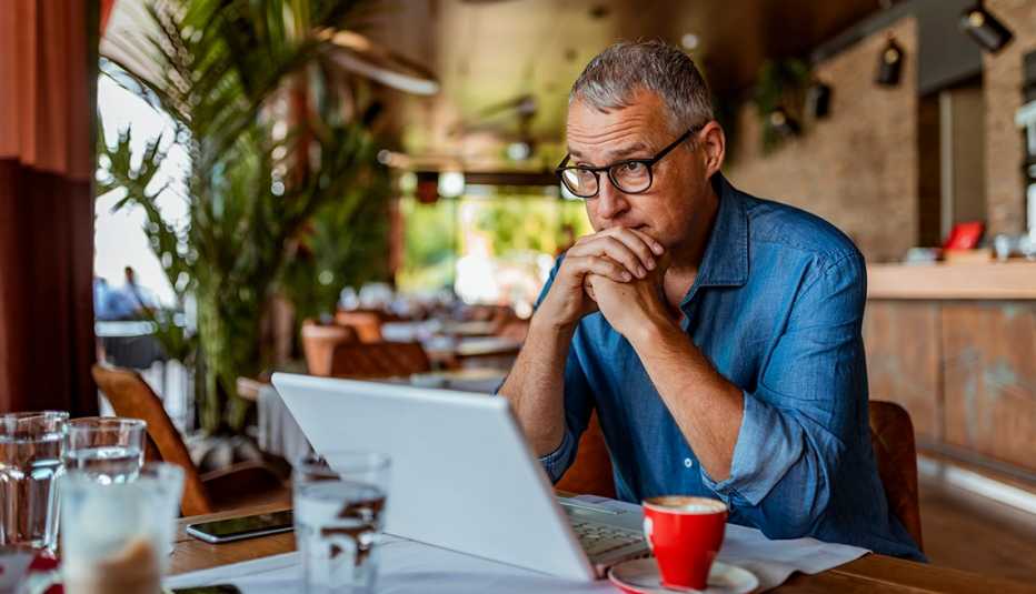 Hombre frente a su computadora y con expresión de preocupación