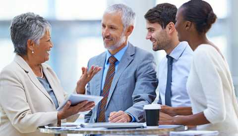 Personas en traje de ejecutivos hablando alrededor de una mesa - Metas para conseguir trabajo Personas en traje de ejecutivos hablando alrededor de una mesa - Metas para conseguir trabajo