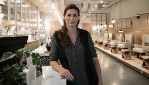 Mujer frente al mostrador de un salón de uñas Mujer frente al mostrador de un salón de uñas
