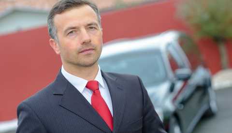 Hombre usando un traje de corbata frente a un carro funerario - Empleos con un salario anual superior a los 100 mil dólares Hombre usando un traje de corbata frente a un carro funerario - Empleos con un salario anual superior a los 100 mil dólares