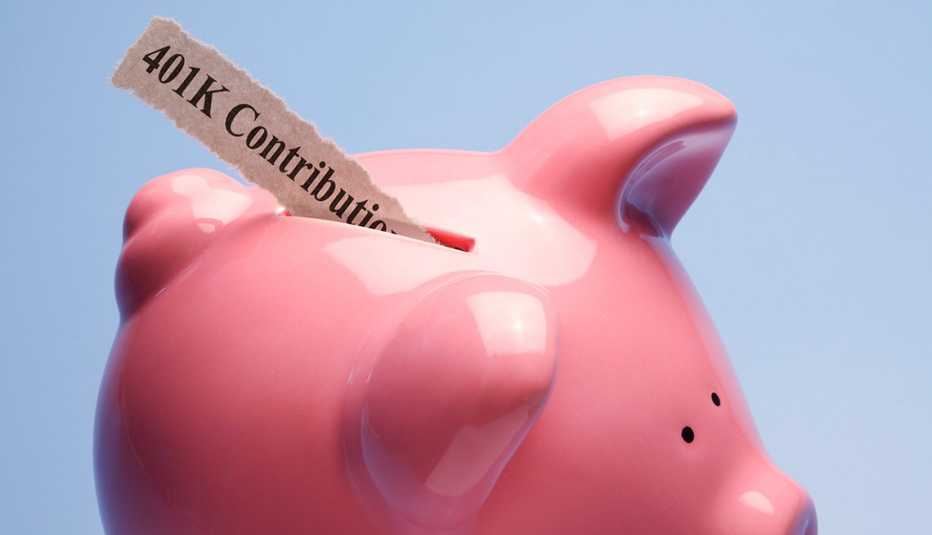 Alcancía en forma de cerdito con un papel que dice en inglés contribuciones para el 401K.