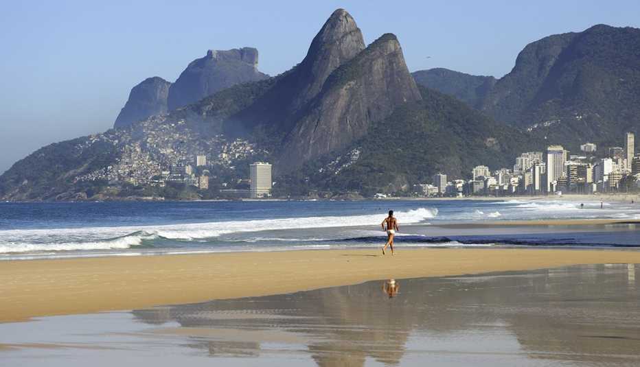 Persona corriendo a la orilla de la playa Copacabana en Río de Janeiro, Brasil