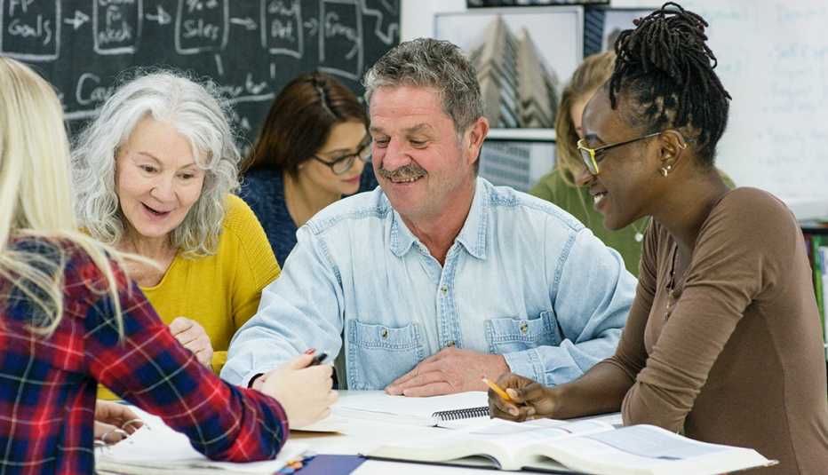 Grupo de personas mayores en un salón de una universidad.