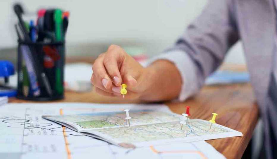 Mujer selecciona destinos en un mapa - 4 razones para acudir a un agente de viaje Mujer selecciona destinos en un mapa - 4 razones para acudir a un agente de viaje