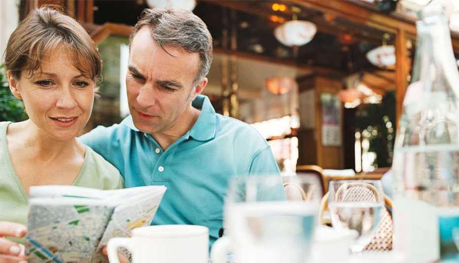 Pareja observa un mapa - Cómo lograr viajes seguros en tiempos difíciles