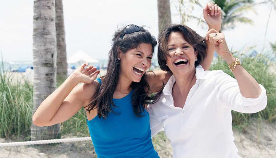 Paseos de primera para madres e hijas - Hija y madre sonríen en la playa Paseos de primera para madres e hijas - Hija y madre sonríen en la playa