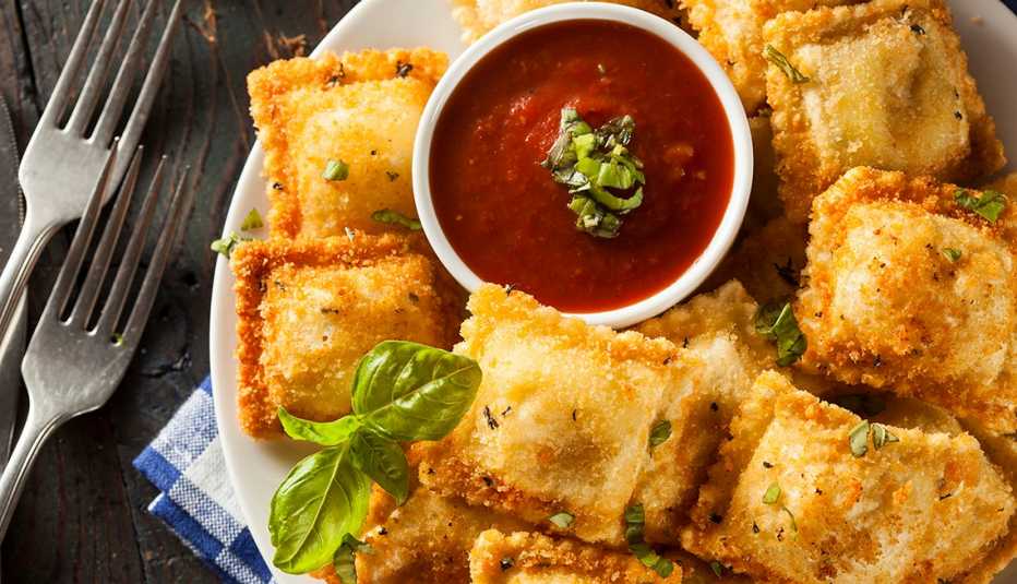 Ravioles fritos caseros con salsa marinara y albahaca.