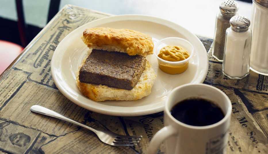 Fried Livermush Biscuit con mostaza y café en la mesa.