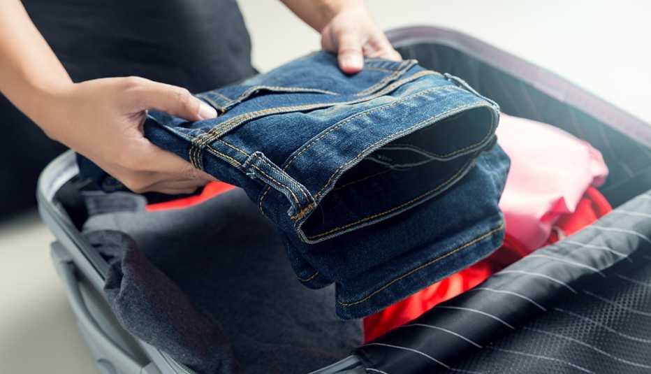 Mujer empaca ropa en una maleta de viaje. Mujer empaca ropa en una maleta de viaje.