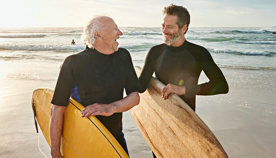Padre e hijo en una playa con tablas de surf
