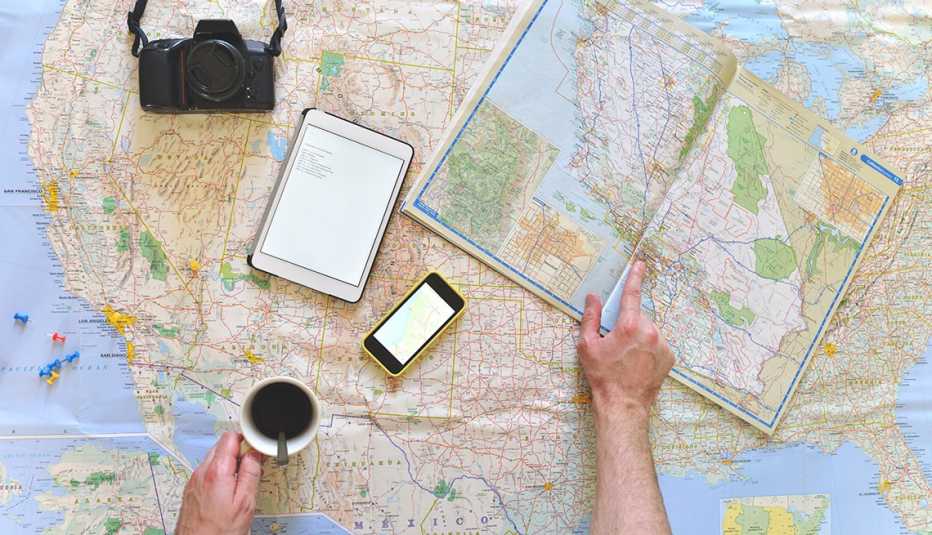 No salgas de casa sin estas aplicaciones - Persona observa un mapa sobre la mesa