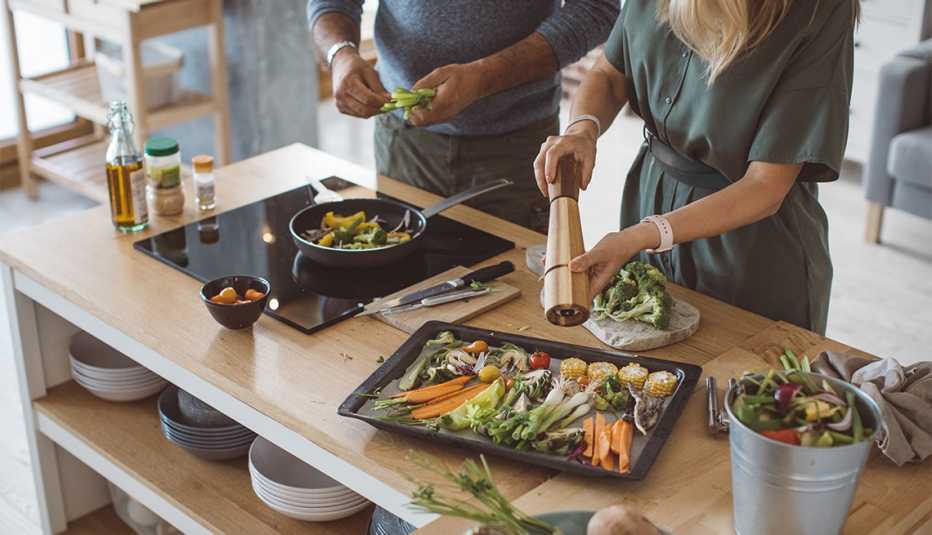 Pareja preparara una comida vegetal recién cosechada del jardín Pareja preparara una comida vegetal recién cosechada del jardín