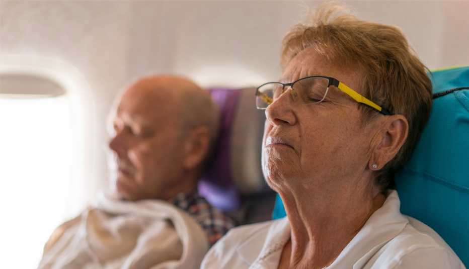 Pareja duerme en un avión Pareja duerme en un avión