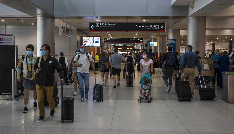 Pasajeros caminan por un aeropuerto Pasajeros caminan por un aeropuerto