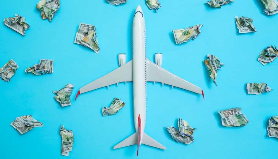 Avión rodeado de billetes de cien dólares arrugados
