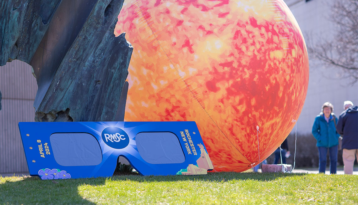 gafas para ver eclipses y un sol inflable en las afueras del Rochester Museum and Science Center en Nueva York
