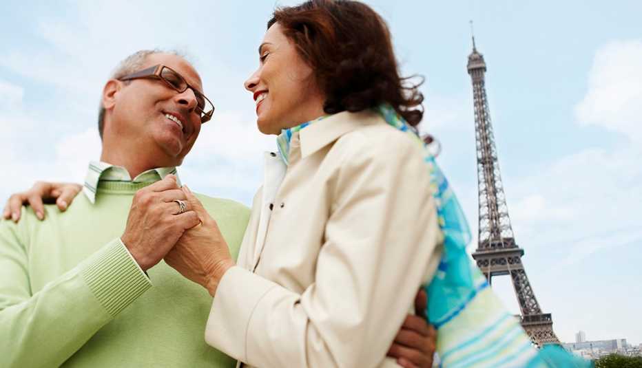 una pareja abrazándose con la Torre Eiffel al fondo una pareja abrazándose con la Torre Eiffel al fondo