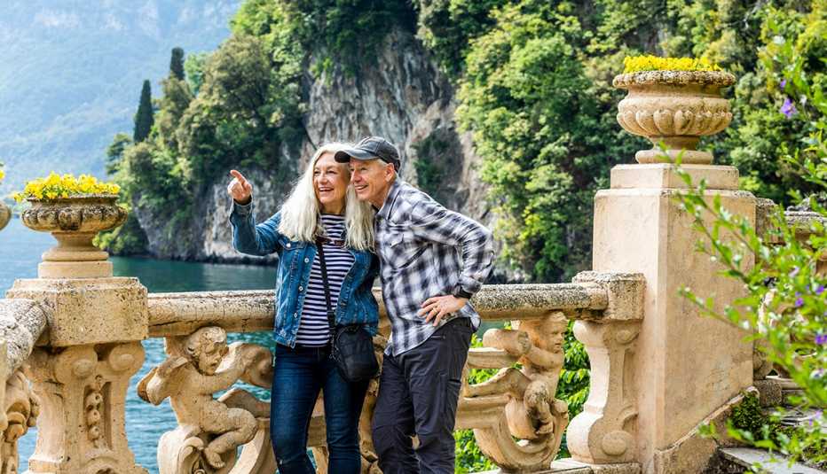 Una pareja de pie sobre una pasarela con vistas al lago de Como, Italia Una pareja de pie sobre una pasarela con vistas al lago de Como, Italia