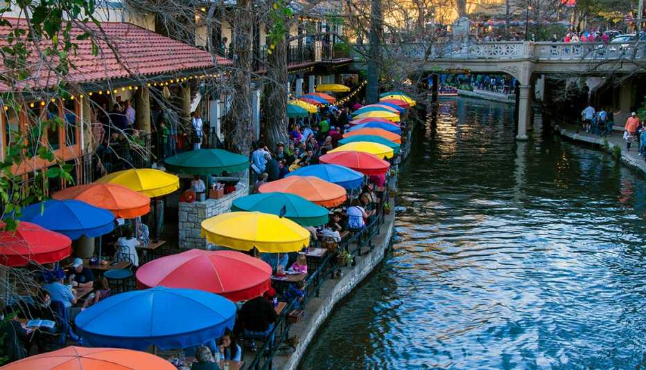 Área urbana con una red de pasarelas y restaurantes a lo largo de las orillas de un río.