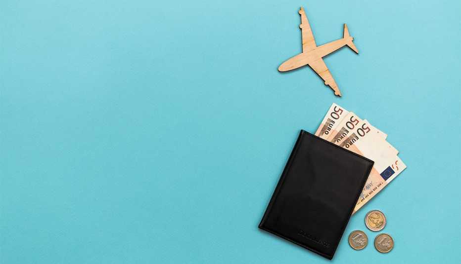 Figura de avión junto a un pasaporte con billetes de euros