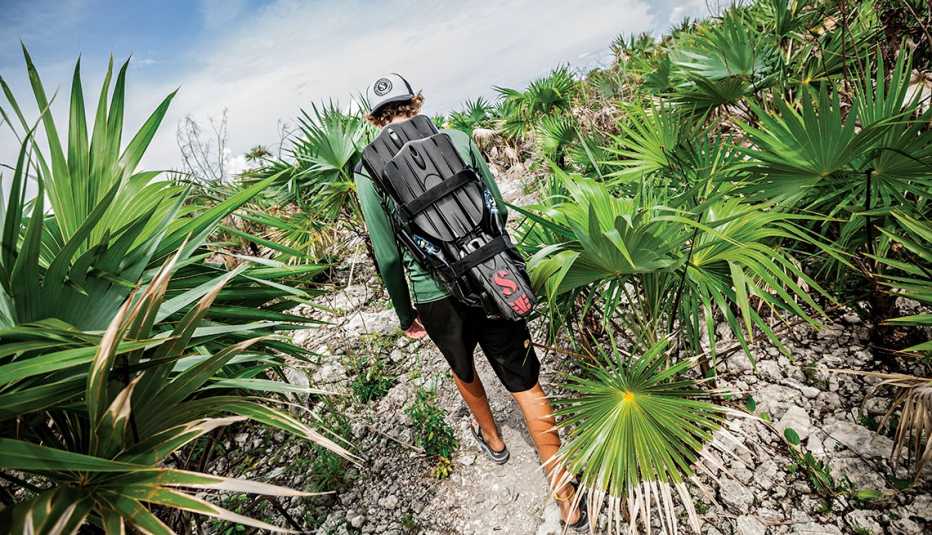 Hombre carga aletas meintras caminan en Turcas y Caicos