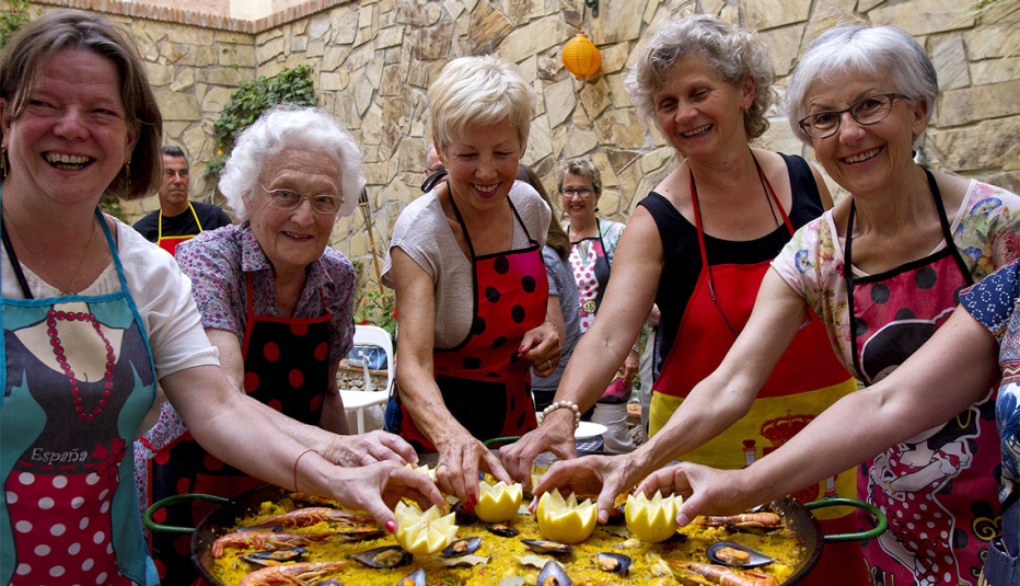 Estudiantes dando los toques finales a una paella en Nerja, España